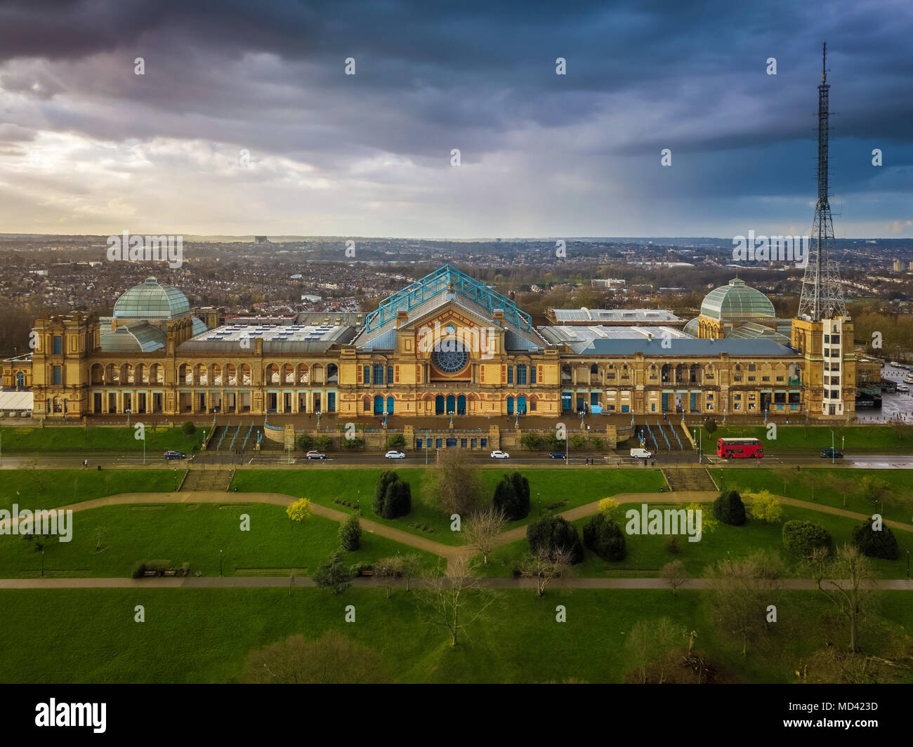 London, England - Aerial panromaic view of Alexandra Palace in Alexandra Park with iconic red double-decker bus and dramatic clouds behind Stock Photo