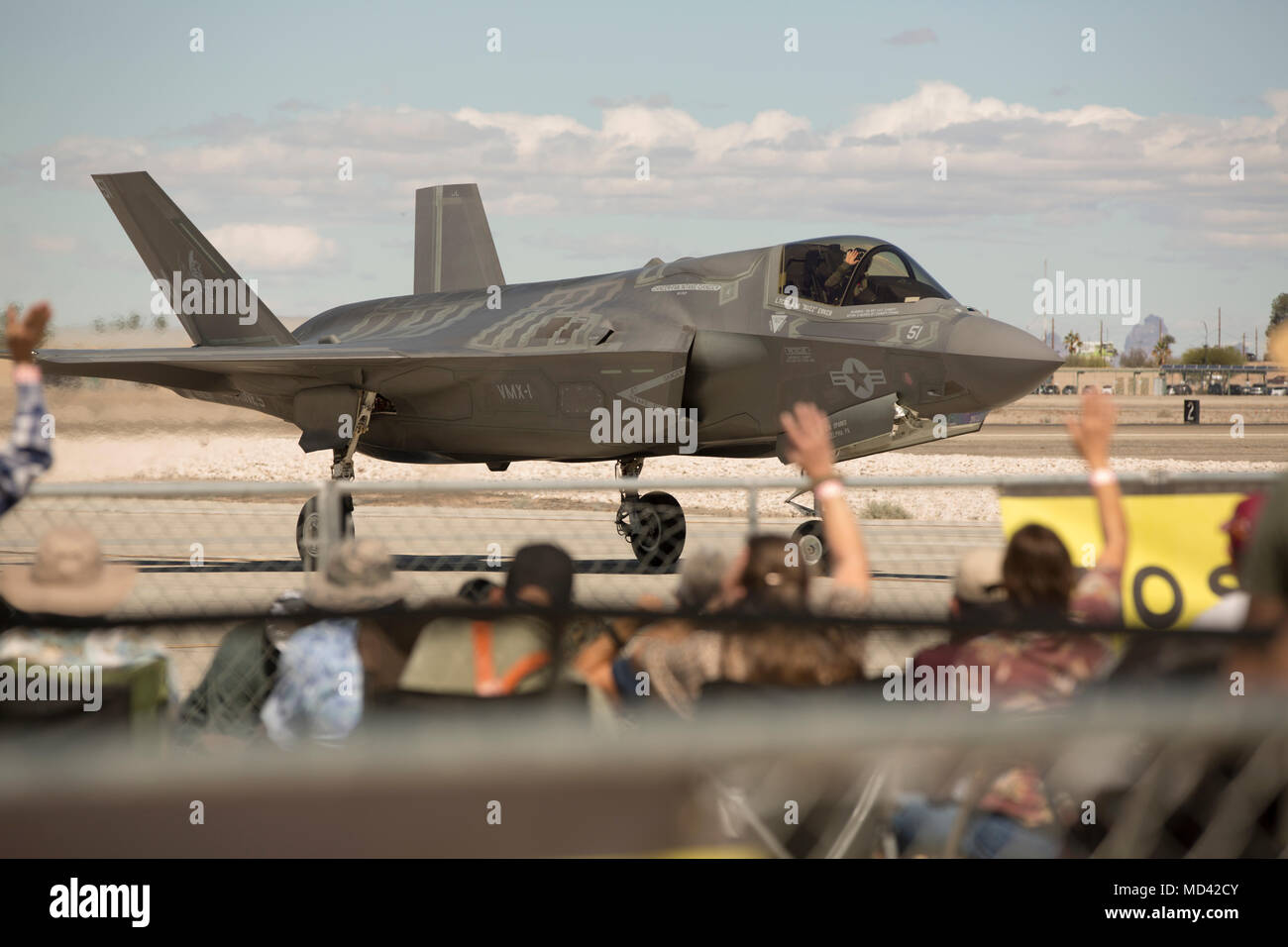 Guests wave to the Marine Corps' F-35B 'Lightning II' pilot as he passes by during the 2018 Yuma Airshow hosted by Marine Corps Air Station Yuma, Ariz., Saturday, March 17, 2018. The airshow is MCAS Yuma's only military airshow of the year and provides the community an opportunity to see thrilling aerial and ground performers for free while interacting with Marines and Sailors. (U.S. Marine Corps photo by Lance Cpl. Sabrina Candiaflores) Stock Photo