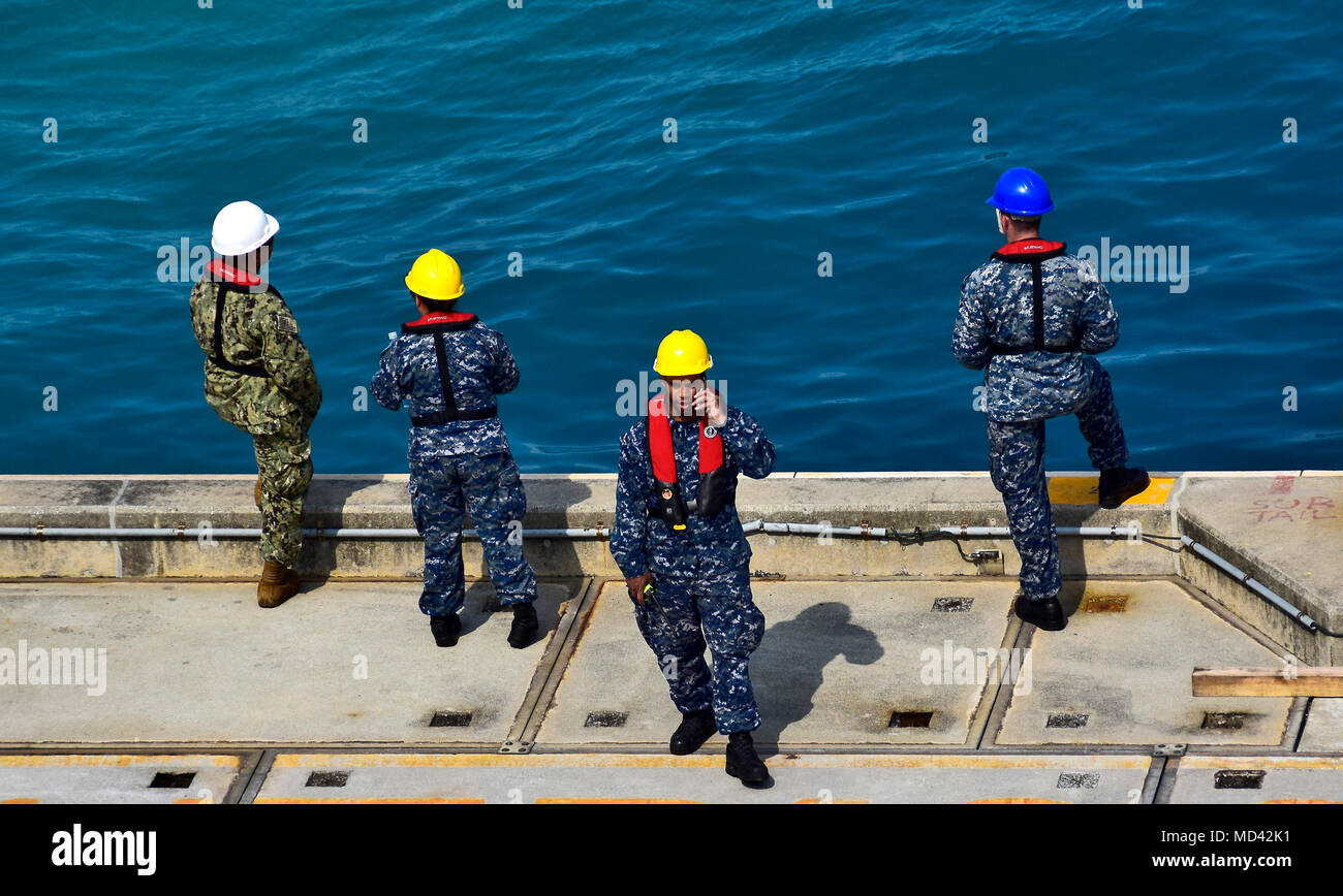 180319-N-RI884-0043 OKINAWA, Japan (March 19, 2018) Sailors assigned to the amphibious assault ship USS Wasp (LHD 1) observe boat operations as the ship prepares to depart Okinawa. Wasp, part of the Wasp Expeditionary Strike Group, with embarked 31st Marine Expeditionary Unit, is operating in the Indo-Pacific region to enhance operability with partners, serve as a ready-response force for any type of contingency and advance the Up-Gunned ESG concept. (U.S. Navy photo by Mass Communication Specialist 1st Class Daniel Barker/Released) Stock Photo