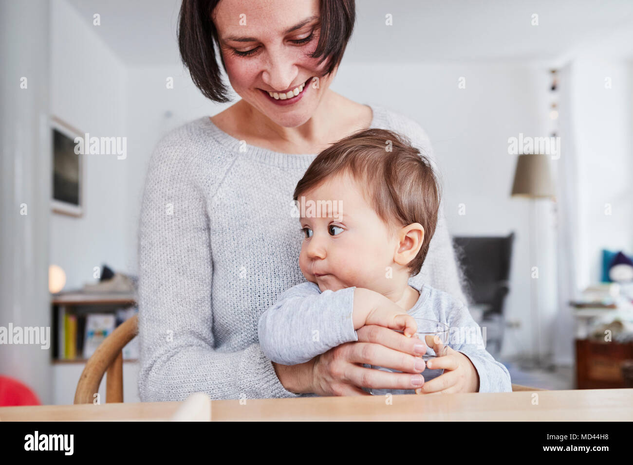Portrait of woman sitting at table with baby daughter Stock Photo