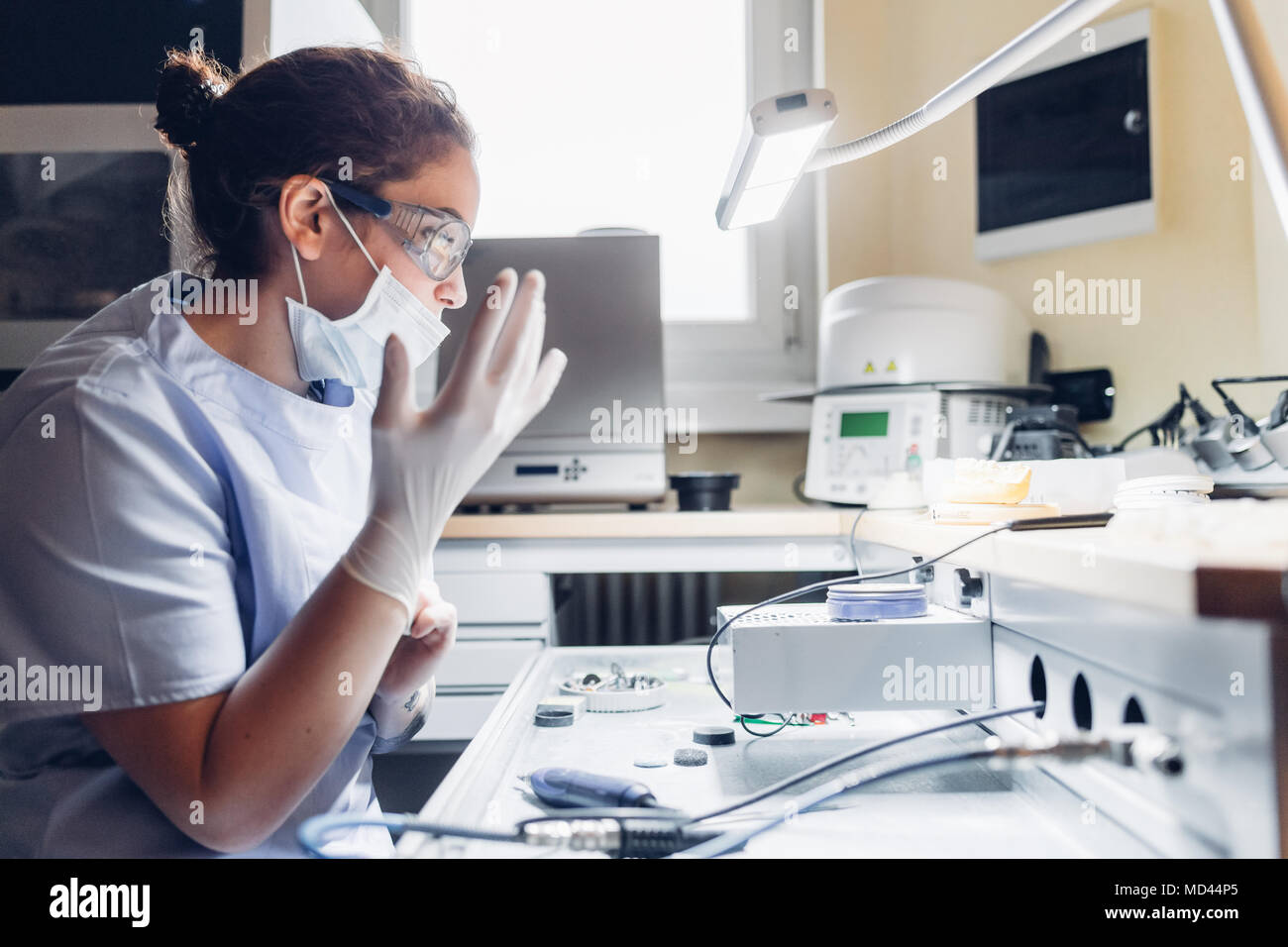 Dentist putting on surgical gloves, preparing to use dentistry