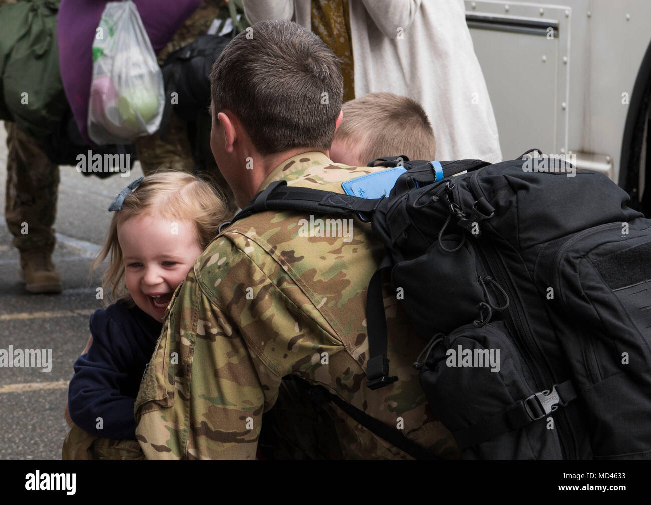 Capt. Andrew Lee, 7th Airlift Squadron C-17 Globemaster III pilot, hugs his children after returning home from a 90-day deployment in the Middle East at Joint Base Lewis-McChord, Wash., March 5, 2018. As a pilot, Lee was a part of the 816th Expeditionary Airlift Squadron at Al Udeid Air Base, Qatar, and flew a C-17 to deliver mission critical cargo and supplies within the area of responsibility. (U.S. Air Force photo by Senior Airman Tryphena Mayhugh) Stock Photo