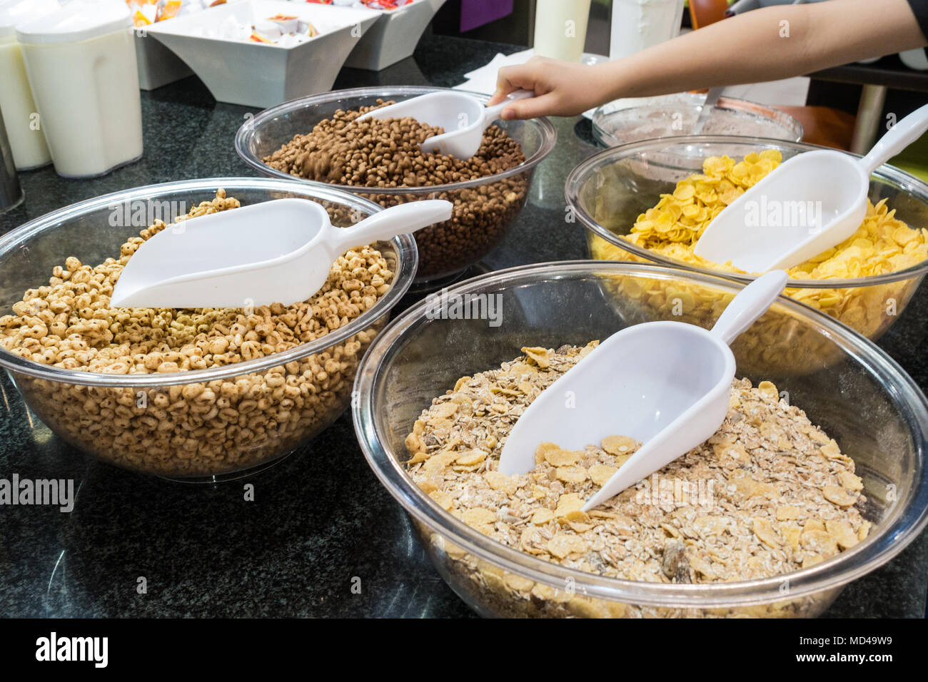A selection of breakfast cereals with plastic scoops at a self service breakfast buffet in a hotel restaurant. Stock Photo