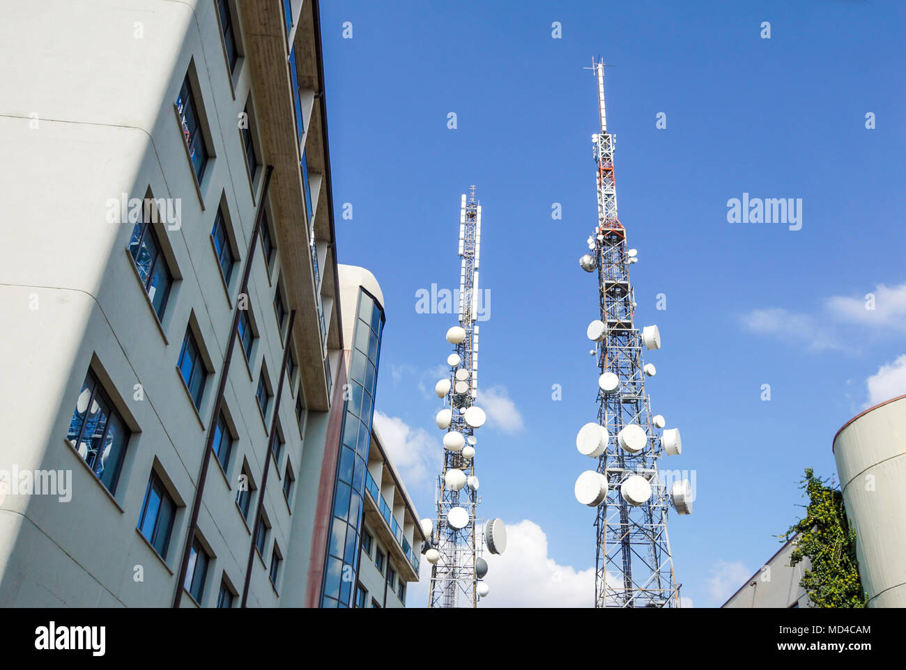 Mobile phone communication antenna tower with satellite dish on blue sky background, Telecommunication tower Stock Photo