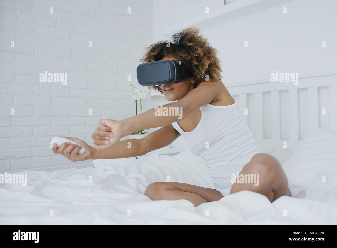 Excited woman sitting in bed hi-res stock photography and images - Alamy