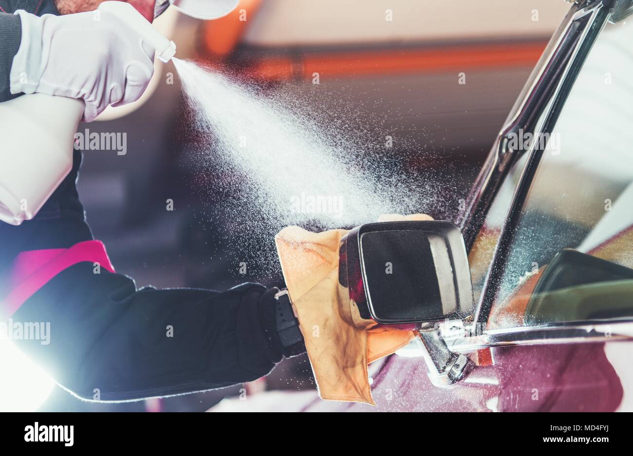 Car Wash Vehicle Detailing. Professional Cleaner Working to Clean Classic Car Body. Stock Photo