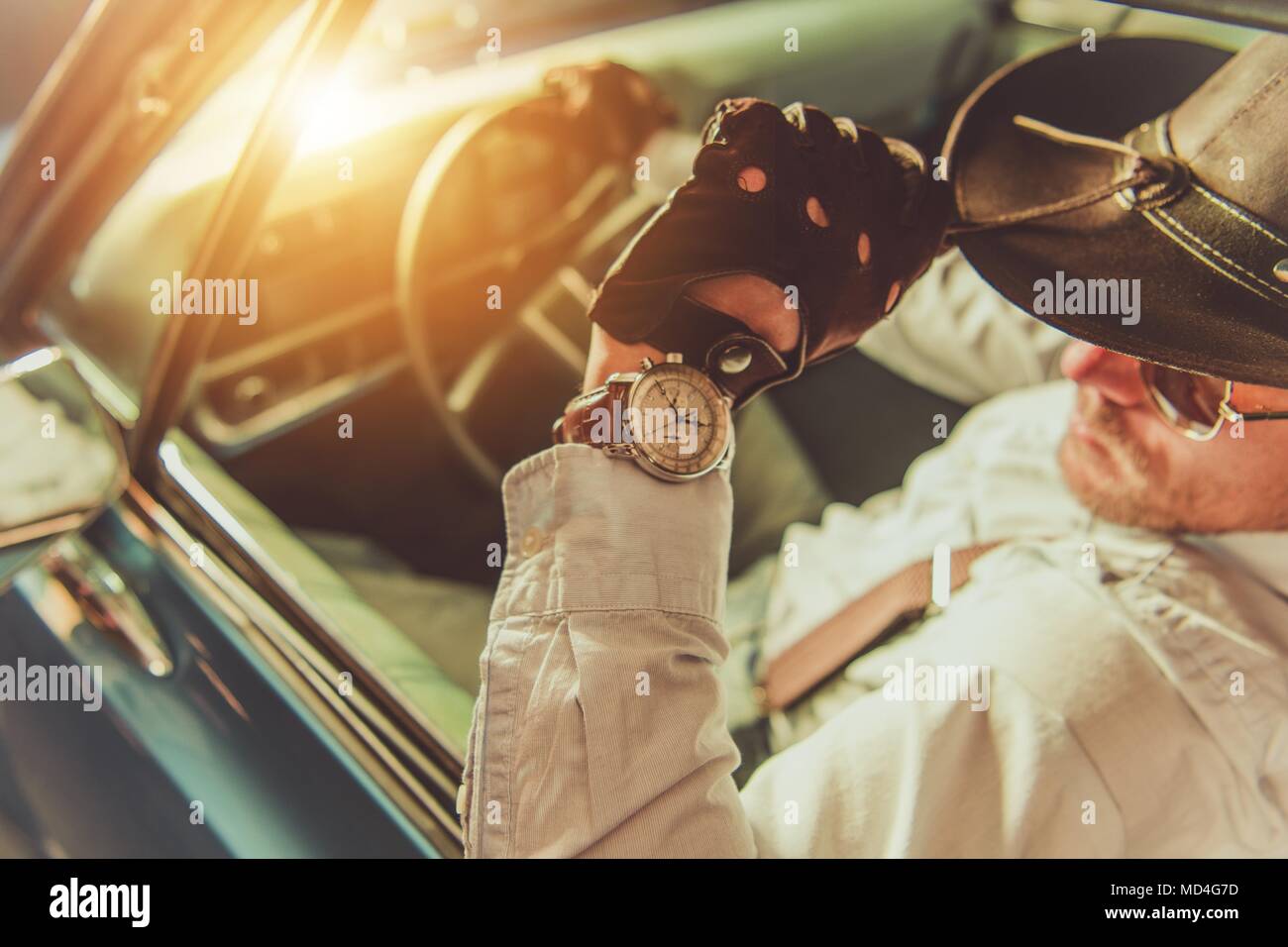 Western Wear Driver. Caucasian Cowboy in the Hat Driving His Classic Muscle Car Stock Photo