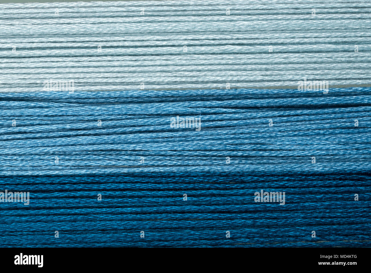 deep blue, blue, light blue and white cotton threads macro close up ...