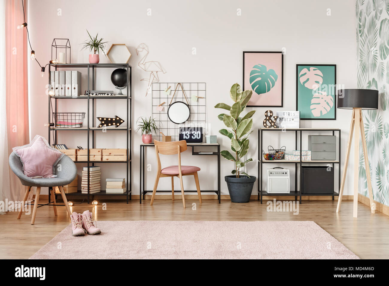 Laptop with clock screensaver placed on a metal desk in bright girl