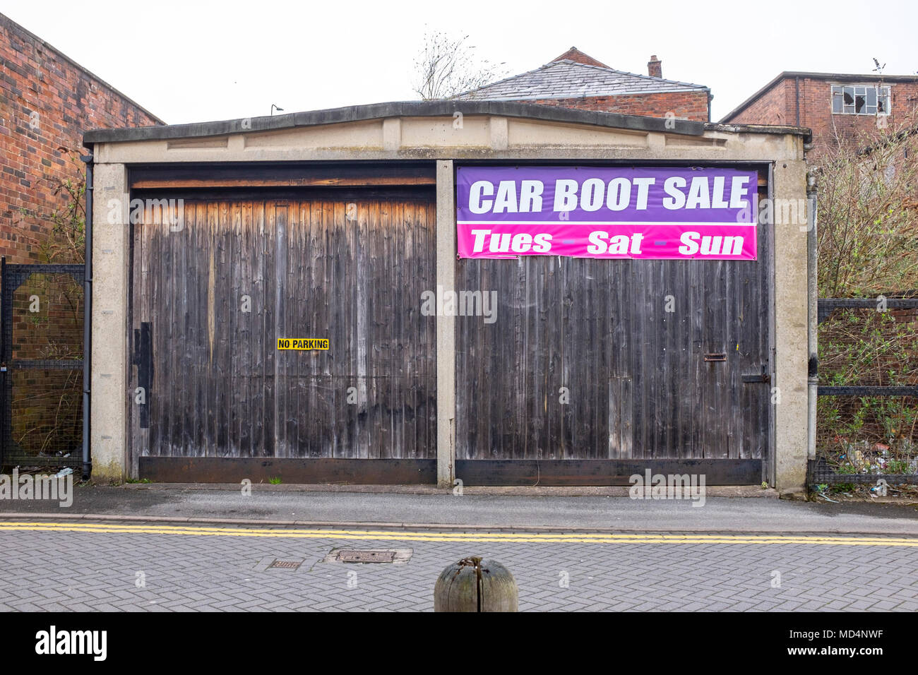 Car boot sale sign on garage door with No Parking sign in Congleton Cheshire UK Stock Photo