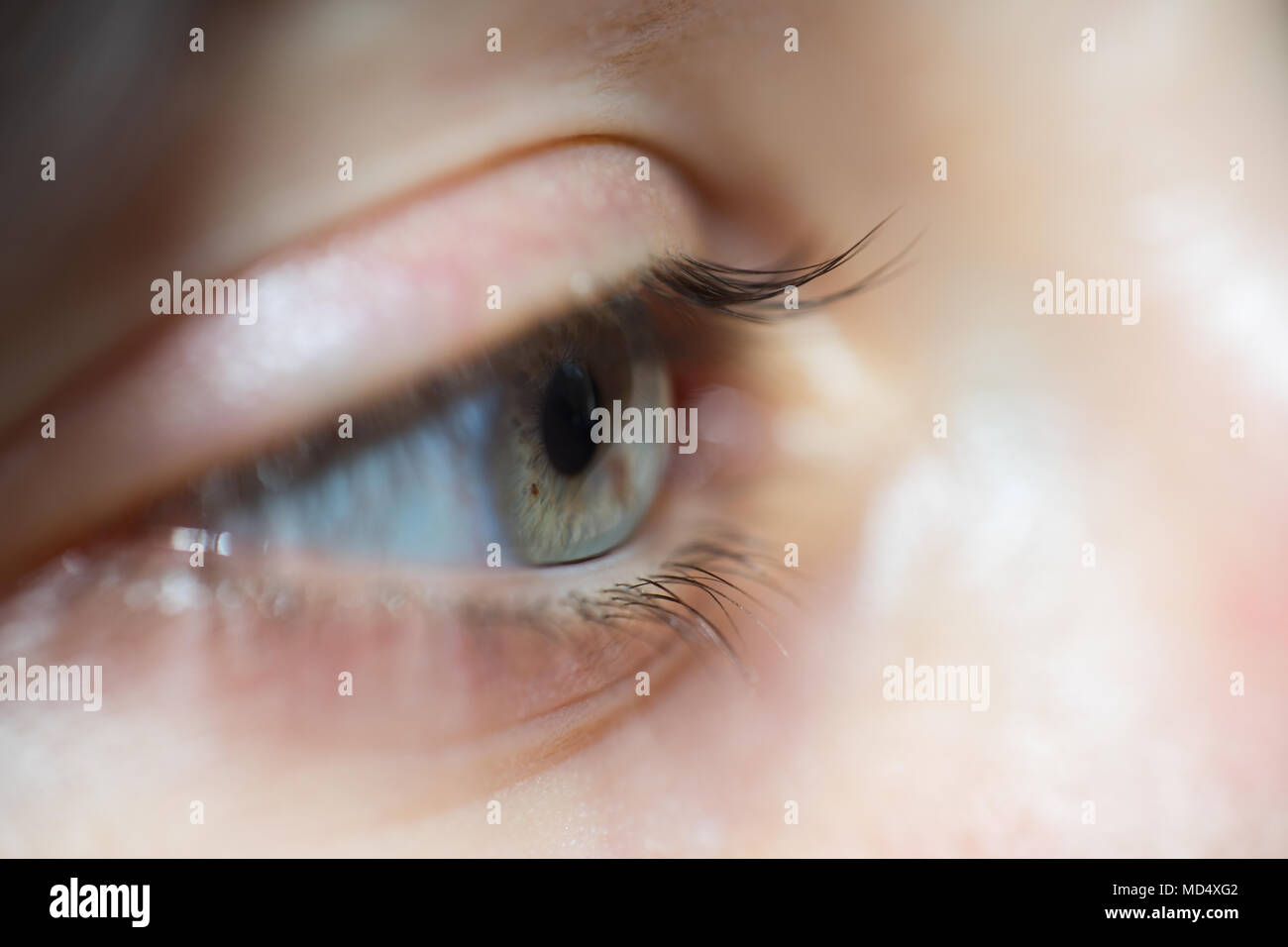 Close-Up Of Woman With Blue Eyes And Long Eyelashes Looking Away In Sadness Stock Photo