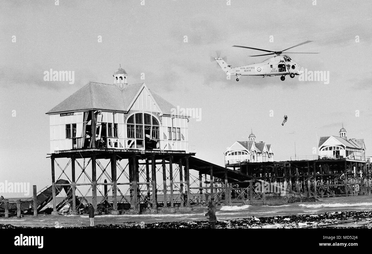 A lifeboatman being lowered from a Royal Air Force rescue helicopter to their storm-battered station at Margate Pier. Stock Photo