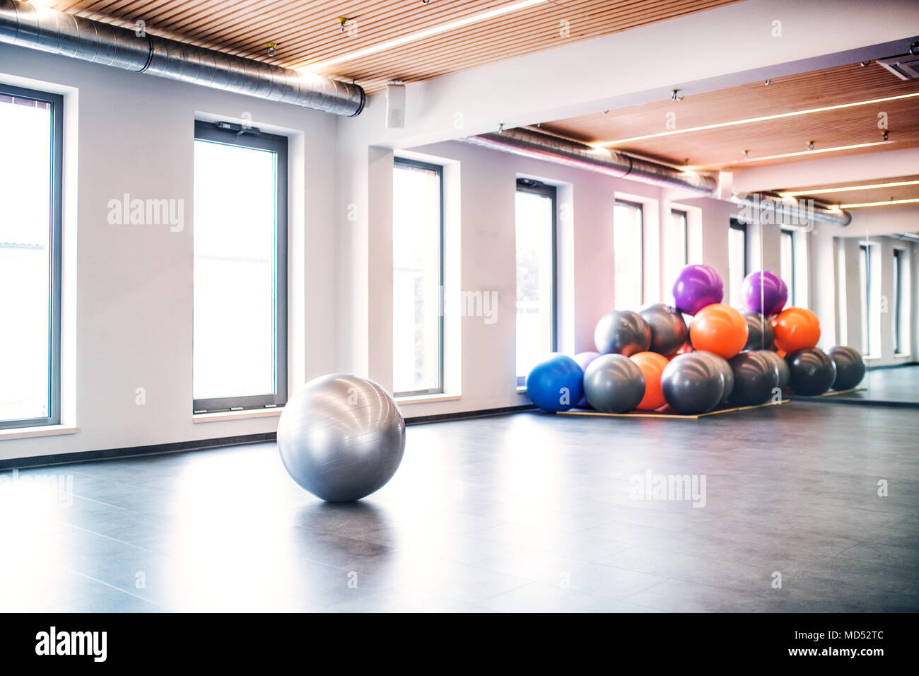 Young woman doing exercise with a fitball in a gym. Stock Photo