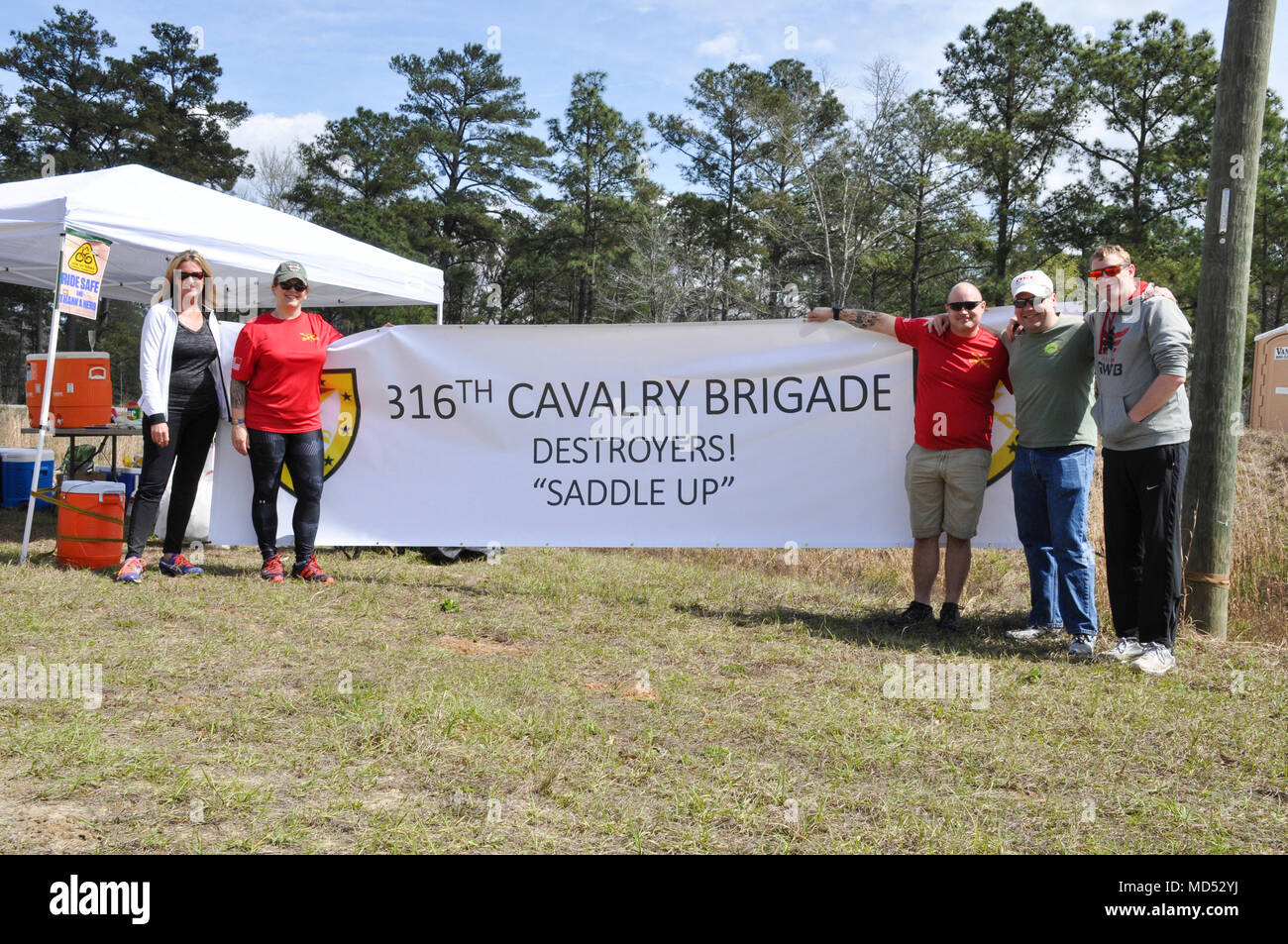 FORT BENNING, Ga. -- Volunteers assigned to the 316th Cavalry Brigade at Fort Benning, Georiga, pose at a rest stop sponsored by the 316th CAV during the Fort Benning Centennial Century Bike Ride at Columbus, Georgia, March 10, 2018. The 100-mile bike race, which leads cyclists through Fort Benning and downtown Columbus, takes place during the the year-long celebration of Fort Benning's 100th anniversary. (U.S. Army photo by Jessica Dupree/Released) Stock Photo