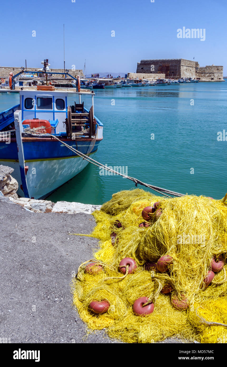 Heraklion, Crete Island / Greece: Traditional fishing boat and fishing nets in front of the fortress Koules (castello a mare) Stock Photo