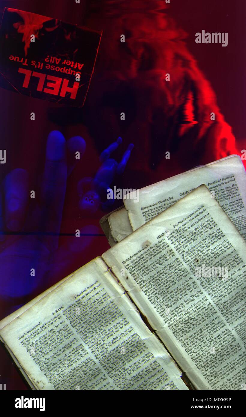 Demon Hand Scriptures Pages from Bible. Demon face, doll and human hand Stock Photo - Alamy
