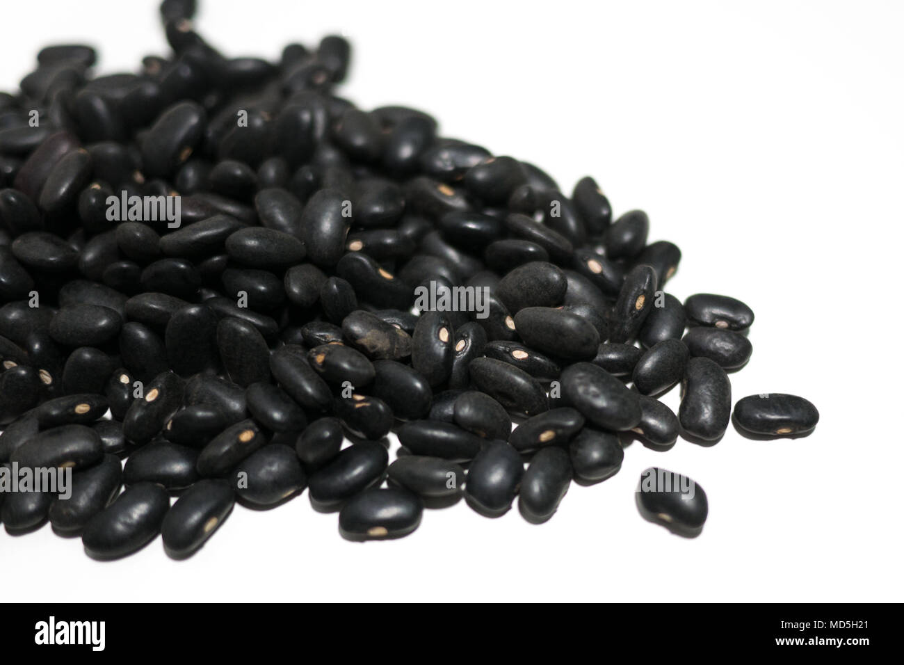 Pile of fresh raw uncooked black beans on white table background. close