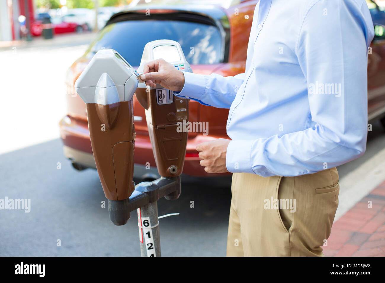 Closeup portrait, young man putting coins in parking meter outside to
