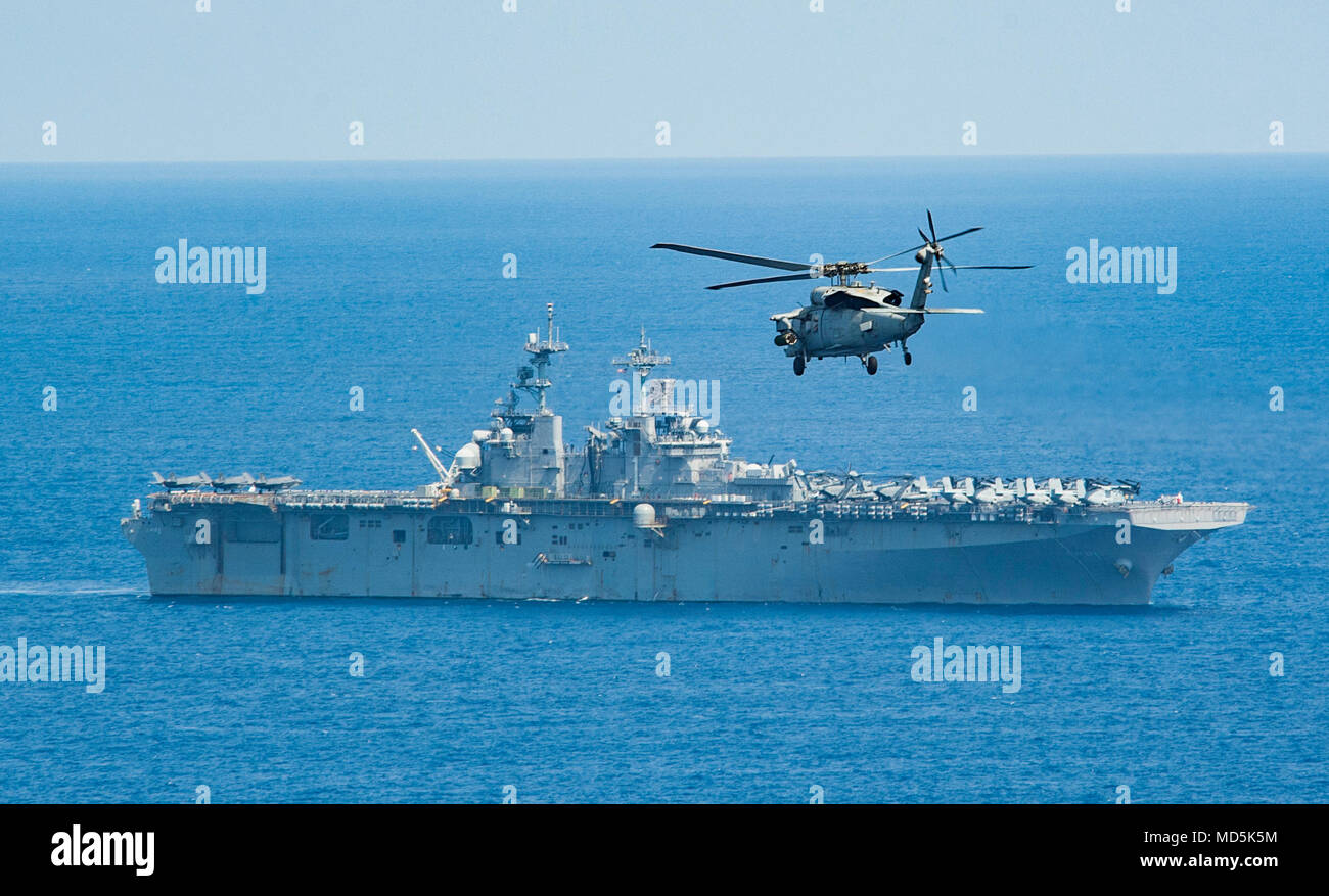 180320-N-NM806-0280  PHILIPPINE SEA(March 20, 2018) An MH-60S Sea Hawk attached to Helicopter Sea Combat Squadron (HSC) 25 approaches the amphibious assault ship USS Wasp (LHD 1). Wasp, part of the Wasp Expeditionary Strike Group, with embarked 31st Marine Expeditionary Unit, is operating in the Indo-Pacific region to enhance operability with partners, serve as a ready-response force for any type of contingency and advance the Up-Gunned ESG concept. (U.S. Navy photo by Mass Communication Specialist 3rd Class Taylor King/Released) Stock Photo