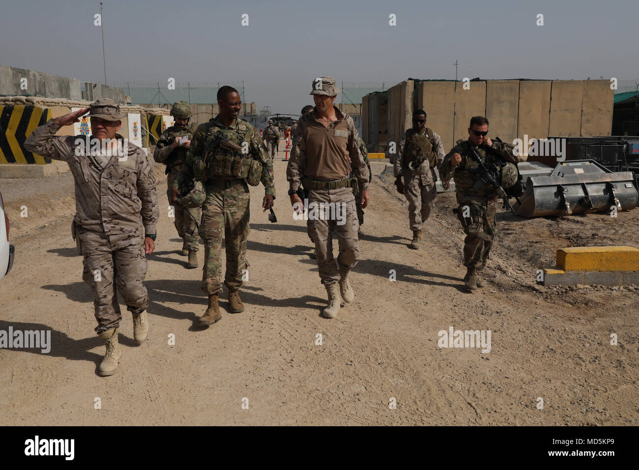 U.S. Army Command Sgt. Maj. Michael Crosby (center) Combined Joint Task Force – Operation Inherent Resolve command sergeant major, and the Task Force Besmaya commander (left) walk with camp leaders during a check on training at the Besmaya Range Complex, Iraq, March 21, 2018. Operation Inherent Resolve is the Global Coalition’s military campaign to defeat ISIS in Iraq and Syria. (U.S. Army photo by Master Sgt. Horace Murray) Stock Photo