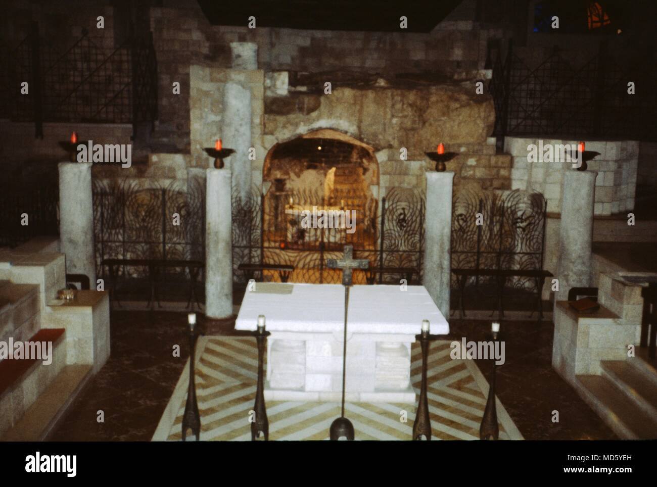 A gated off area that contains religious relics inside the dimly lit interior of a church, 1975. () Stock Photo