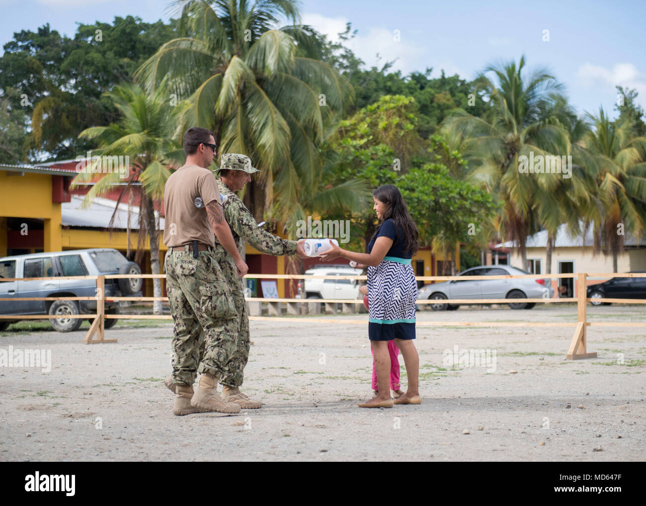 180322-N-UP035-0248 PUERTO CORTES, Honduras (March 22, 2018) Capt. Angel Cuz, Commodore of Destroyer Squadron (DESRON) 40, hands a package of toilet paper to a Honduran girl at the Franklin D. Roosevelt School in Puerto Cortes, Honduras during Continuing Promise 2018. U.S. Naval Forces Southern Command/U.S. 4th Fleet has deployed a force to execute Continuing Promise to conduct civil-military operations including humanitarian assistance, training engagements, and medical, dental, and veterinary support in an effort to show U.S. support and commitment to Central and South America. (U.S. Navy ph Stock Photo
