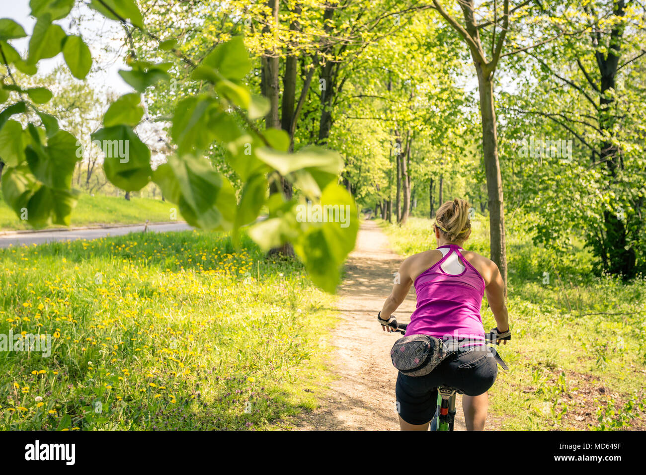 Woman cycling a mountain bike in a city park, summer day. Inspire and ...