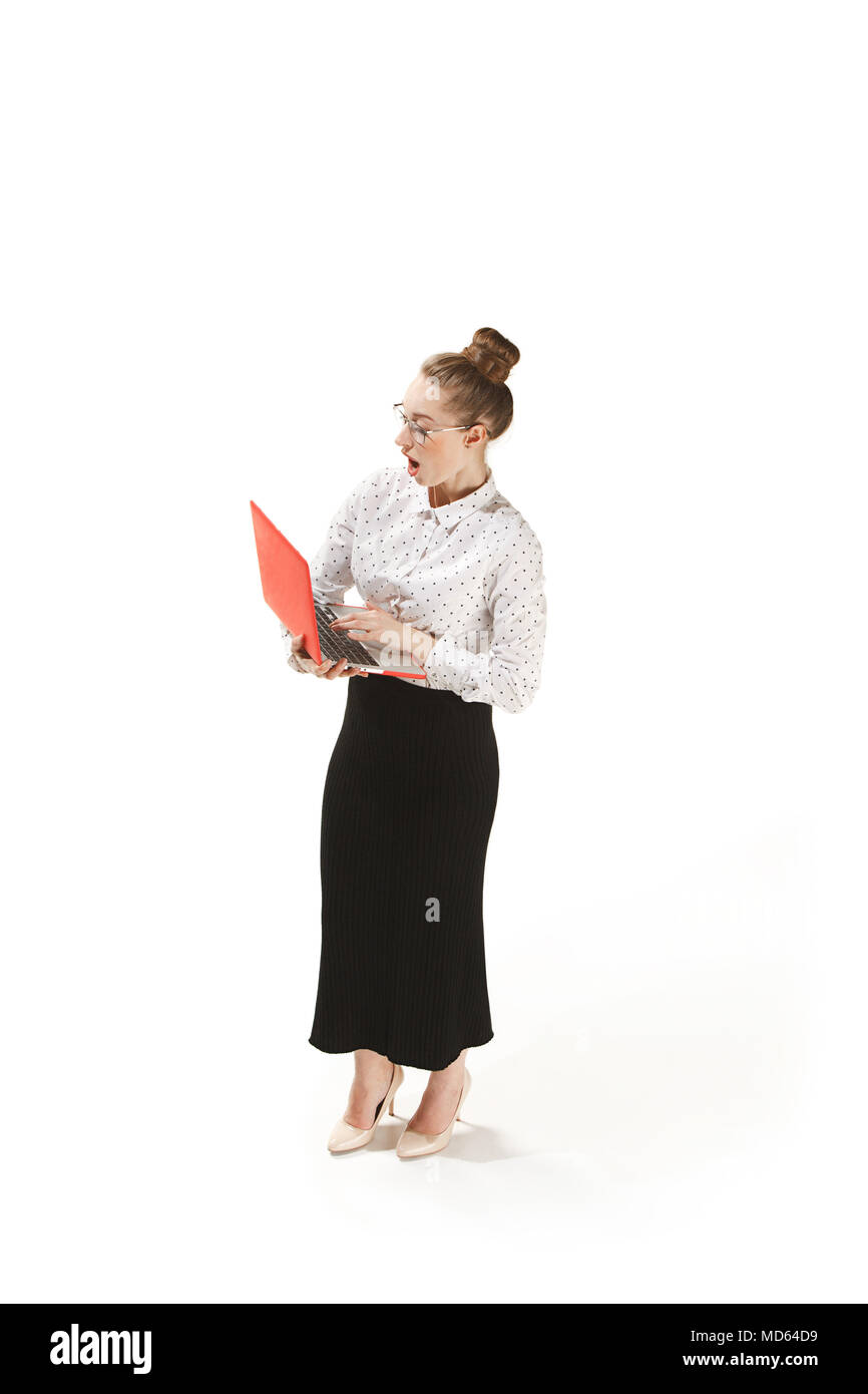 Full length portrait of a smiling female teacher holding a laptop isolated against white background Stock Photo