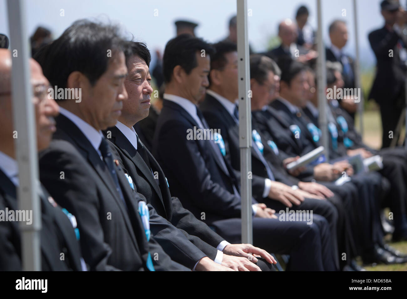 Yoshitaka Shindo, a member of the Japanese house of Representatives and grandson of General Tadamichi Kuribayashi, the commander of the Japanese forces that defended Iwo Jima, listens along with his fellow countrymen as Mr. Katsunobu Kato, the Japanese Minister of Health, Labour and Welfare, addresses the audience during the 73rd Reunion of Honor March 24, 2018 at Iwo To, Japan. The Reunion of Honor was created to commemorate those who fought during the Battle of Iwo Jima. (U.S. Marine Corps photo by Lance Cpl. Jamin M. Powell) Stock Photo