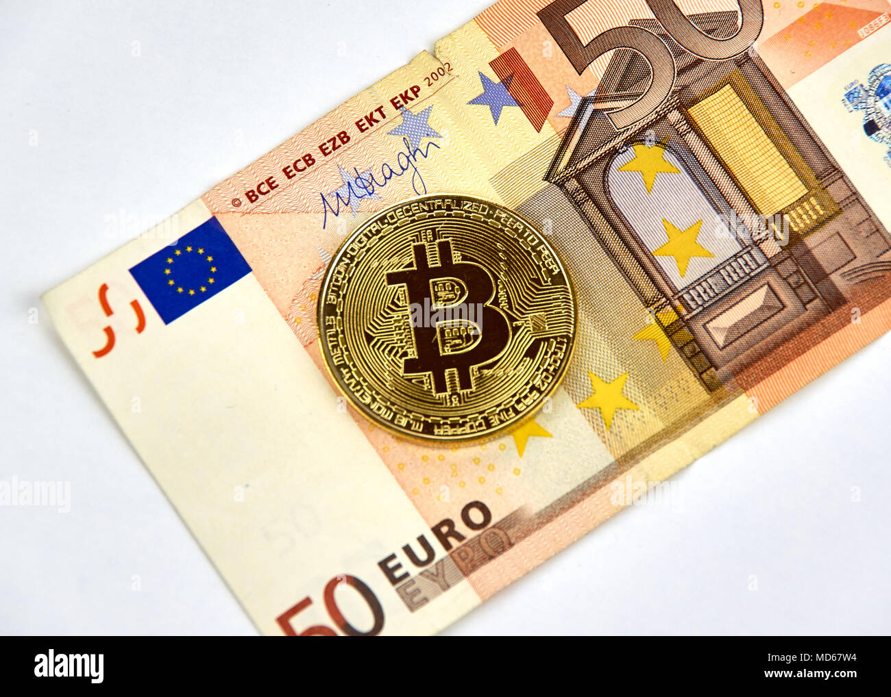 MONTREAL, CANADA - MARCH 10, 2018: Bitcoin cryptocurrency gold coin and logo on Fifty Euro bank note. Stock Photo
