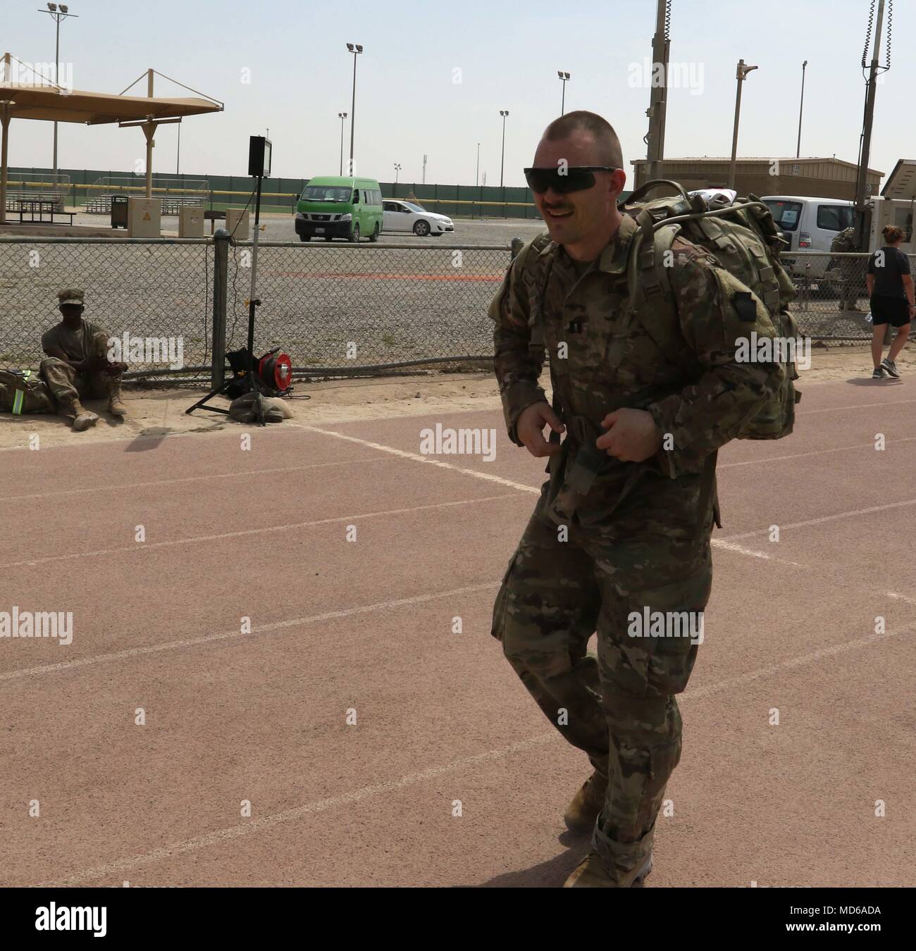 CAMP ARIFJAN, Kuwait – Capt. Corey Clark, mission command integration officer for the 28th Infantry Division, Task Force Spartan, and a Hollidaysburg, Pa. native, happily unclasps the straps on his rucksack after finishing the Bataan Death March on March 25, 2018. Clark and other 28 ID soldiers honored the actual forced march by suffering through a 26.2 mile march in Kuwait. (U.S. Army Photo by Staff Sgt. Matthew Keeler) Stock Photo