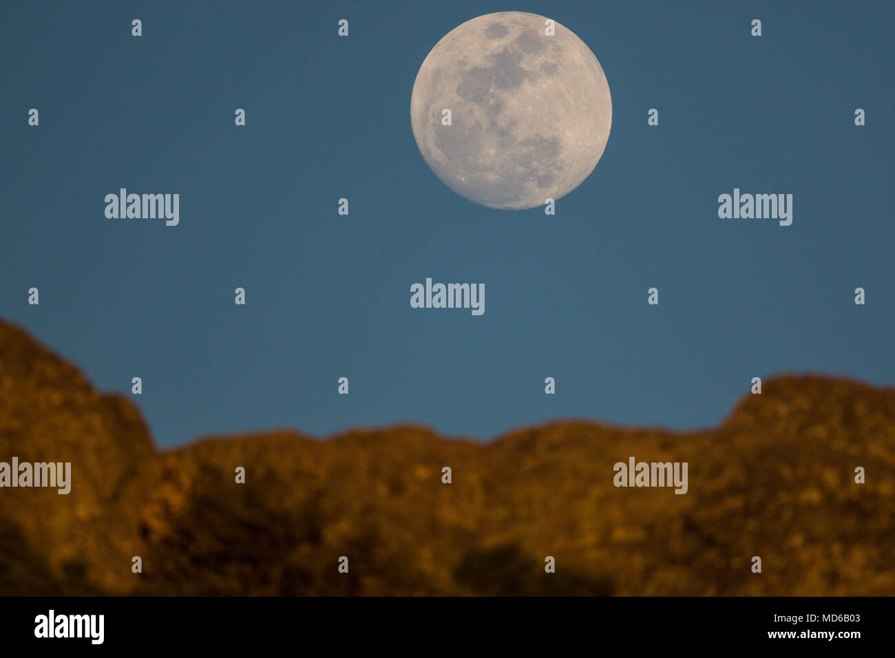 La Luna llena de febrero, conocida como Luna de Nieve, pudo verse mientras el satélite ingresaba en la zona de penumbra de la Tierra, en lo que se conoce como un eclipse penumbral. Aqui se observa su salida en el horizonte de los cerrros cercanos a Creel, Chihuahua, Mexico donde habita la comunidad indigena raramuri The full moon of February, known as Snow Moon, could be seen as the satellite entered the penumbra zone of the Earth, in what is known as a penumbral eclipse. Here it is observed its exit in the horizon of the hills near Creel, Chihuahua, Mexico where inhabits the indigenous commun Stock Photo