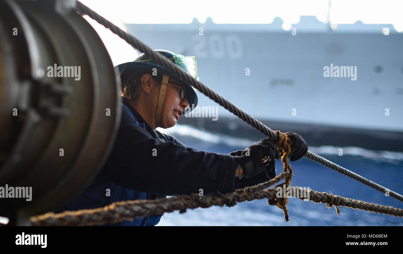 180329-N-NG033-1387 INDIAN OCEAN (March 29, 2018) Boatswain’s Mate 3rd Class Victoria De La Pena cuts through a stopper aboard the aircraft carrier USS Theodore Roosevelt (CVN 71) during a replenishment-at-sea with the fleet replenishment oiler USNS Guadalupe (T-AO 200). Theodore Roosevelt is currently underway for a regularly scheduled deployment in the U.S. 7th Fleet area of operations in support of maritime security operations and theater security cooperation efforts. (U.S. Navy photo by Mass Communication Specialist Seaman Michael Hogan/Released) Stock Photo