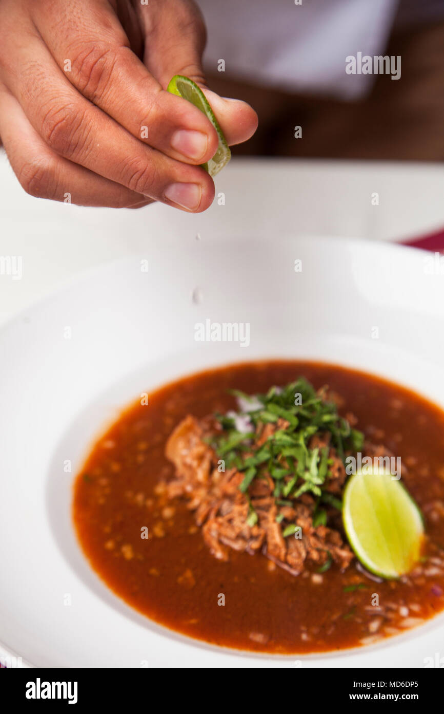 Lime squeezed onto birria de res de Tepic (spicy beef stew), Emiliano Restaurant ,  Tepic, Riviera Nayarit, Mexico Stock Photo