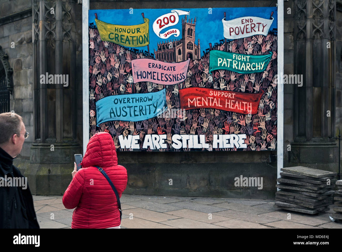A couple viewing a piece of political art at St John's Church on Princes Street, Edinburgh, Scotland, UK. Stock Photo