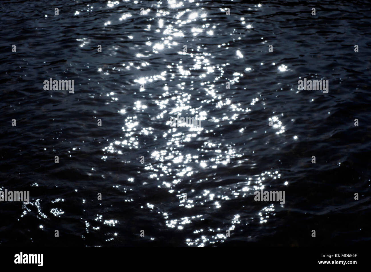 Blured sunset lights shining on the water. Stock Photo