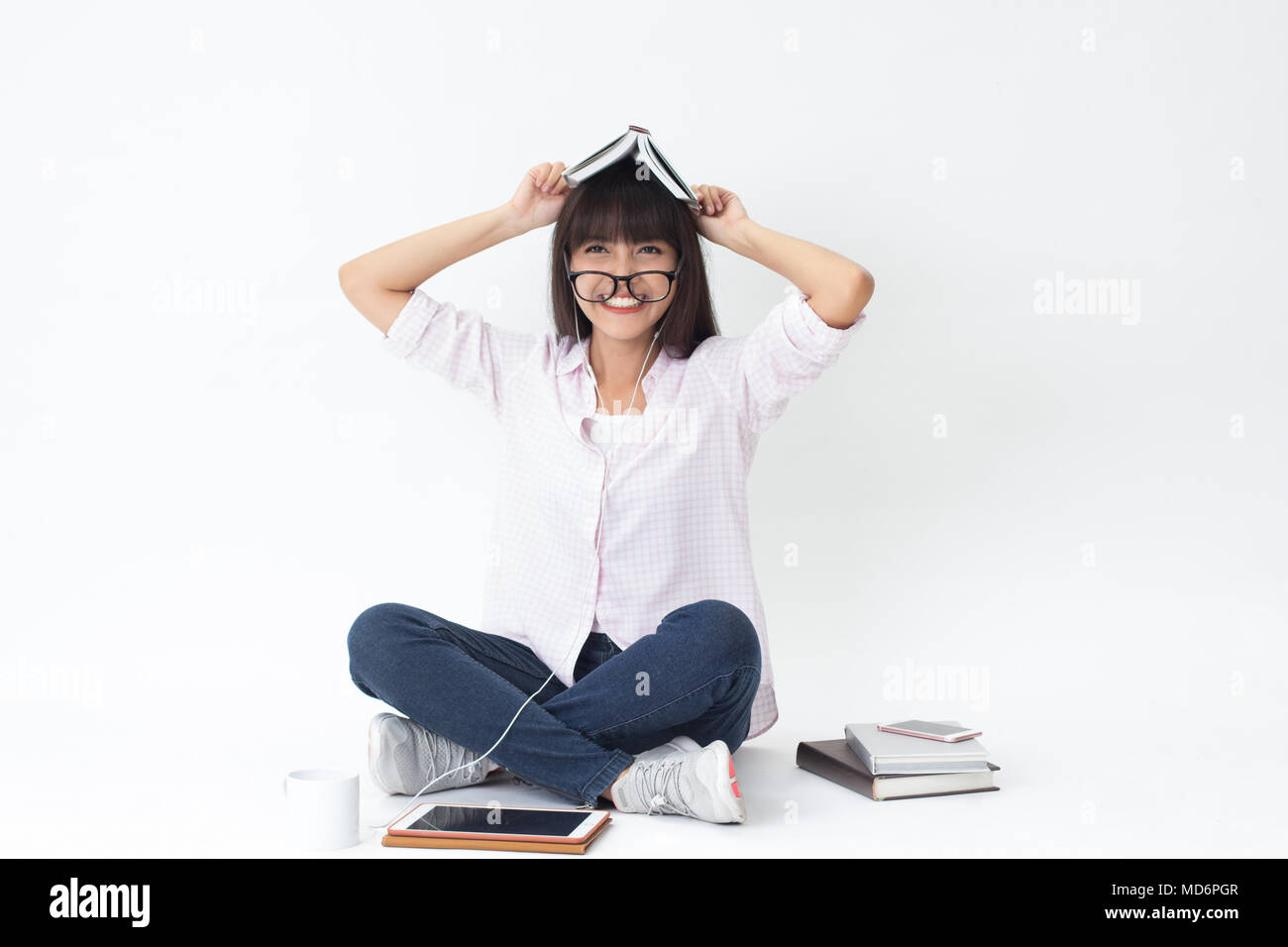Beautiful Thai girl learning and study hard sitting on white background Stock Photo