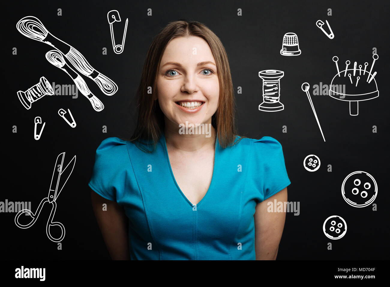 Positive young tailor smiling while waiting for her client Stock Photo ...