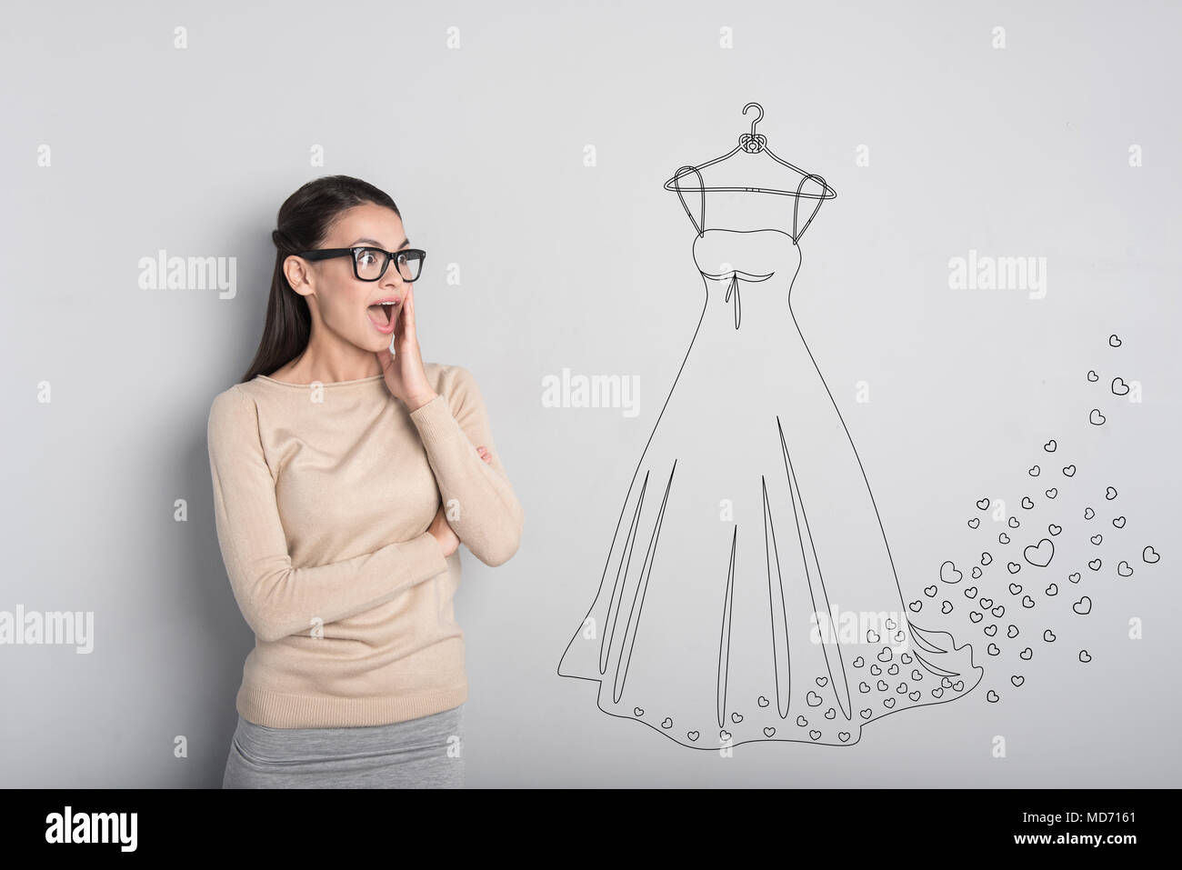 Young bride looking at her wedding dress and feeling happy Stock Photo