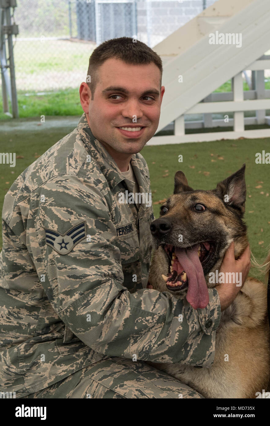 Senior Airman Jesse Terrigino, 2nd Security Forces Squadron military working dog trainer, and Kuno, 2nd SFS MWD, pose for a photo after the completion of Kuno’s retirement ceremony at Barksdale Air Force Base, La., March 16, 2018. Kuno was adopted by Terrigino and is staying with him for the rest of his life. (U.S. Air Force photo by Airman 1st Class Tessa B. Corrick) Stock Photo