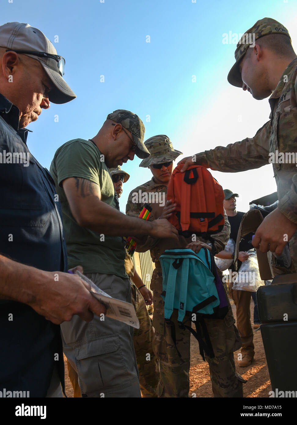 U.S. Army Soldiers with Animal Company, 3rd Battalion, 141st Infantry Regiment, assigned to Combined Joint Task Force - Horn of Africa (CJTF-HOA) put school supplies into backpacks to be given to Somali children in Ali Oune, Djibouti, March 28, 2018. CJTF-HOA service members donated more than $400 of school supplies and sandals to Somali refugees in Djibouti. (U.S. Air Force photo by Staff Sgt. Timothy Moore) Stock Photo