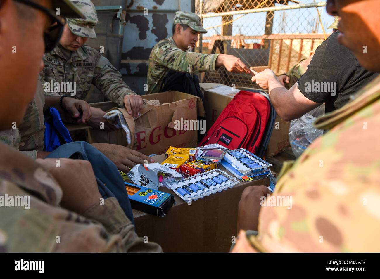 U.S. Army Soldiers with Animal Company, 3rd Battalion, 141st Infantry Regiment, assigned to Combined Joint Task Force - Horn of Africa (CJTF-HOA) put school supplies into backpacks to be given to Somali children in Ali Oune, Djibouti, March 28, 2018. CJTF-HOA service members donated more than $400 of school supplies and sandals to Somali refugees in Djibouti. (U.S. Air Force photo by Staff Sgt. Timothy Moore) Stock Photo