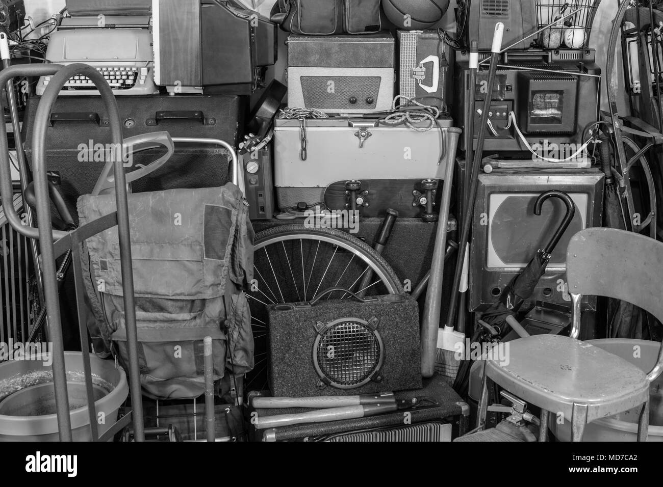 Vintage garage storage area with old tools, gardening, music and sports equipment in black and white. Stock Photo