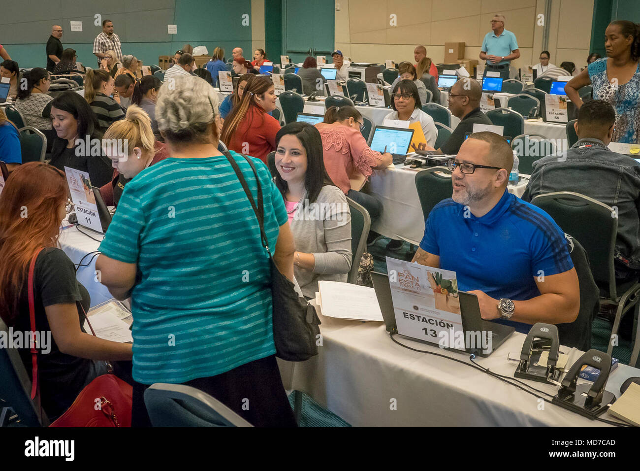 Thousands of residents line up at the San Juan Convention Center, Puerto Rico, March 22, 2018, to receive their share of the $1.27 billion grant for emergency relief and Nutrition Assistance Program (NAP) after Hurricane Maria. The temporary program will provide one year financial assistance towards nutrition assistance for those who qualify. The program is funded by the U.S. Department of Agriculture (USDA) and administered by the Departamento de la Familia. Stock Photo