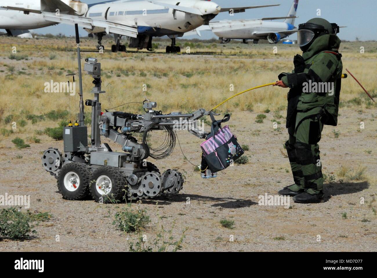 Staff Sgt. Michael Sprouse from San Diego, Calif., an explosive ordnance disposal team leader with the 741st Ordnance Company, 3rd Ord. Battalion., at Fort Bliss, Texas, passes off a suspected exercise improvised explosive device to an ANDROS EOD robot at Pinal Air Park, Ariz. during Raven’s Challenge XII, March 19-23. The Raven’s Challenge Exercise is an annual, interagency, counter IED exercise that incorporates scenarios focused on interoperability capabilities between public safety bomb squads (PSBSs) and military EOD units in operational environments. Stock Photo