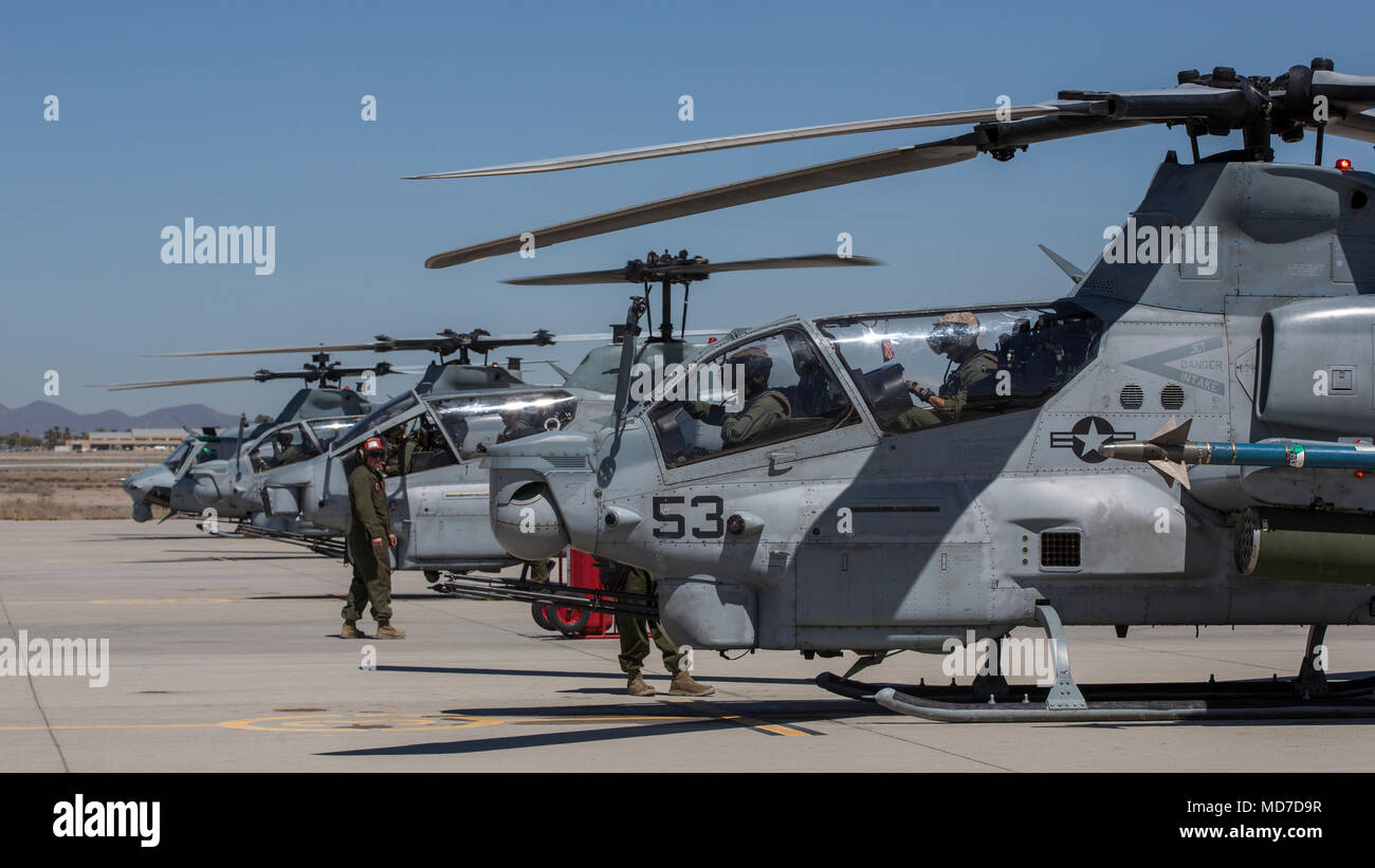 U.S. Marines assigned to Marine Aviation Weapons and Tactics Squadron 1 prepare AH-1Z Vipers, an AH-1W Super Cobra and an UH-1Y Venom during an Advanced Precision Kill Weapon System loading and flight takeoff exercise in support of Weapons and Tactics Instructor course 2-18 at Marine Corps Air Station Yuma, Ariz., March 29. WTI is a seven-week training event hosted by MAWTS-1 cadre, which emphasizes operational integration of the six functions of Marine Corps aviation in support of a Marine Air Ground Task Force and provides standardized advanced tactical training and certification of unit ins Stock Photo