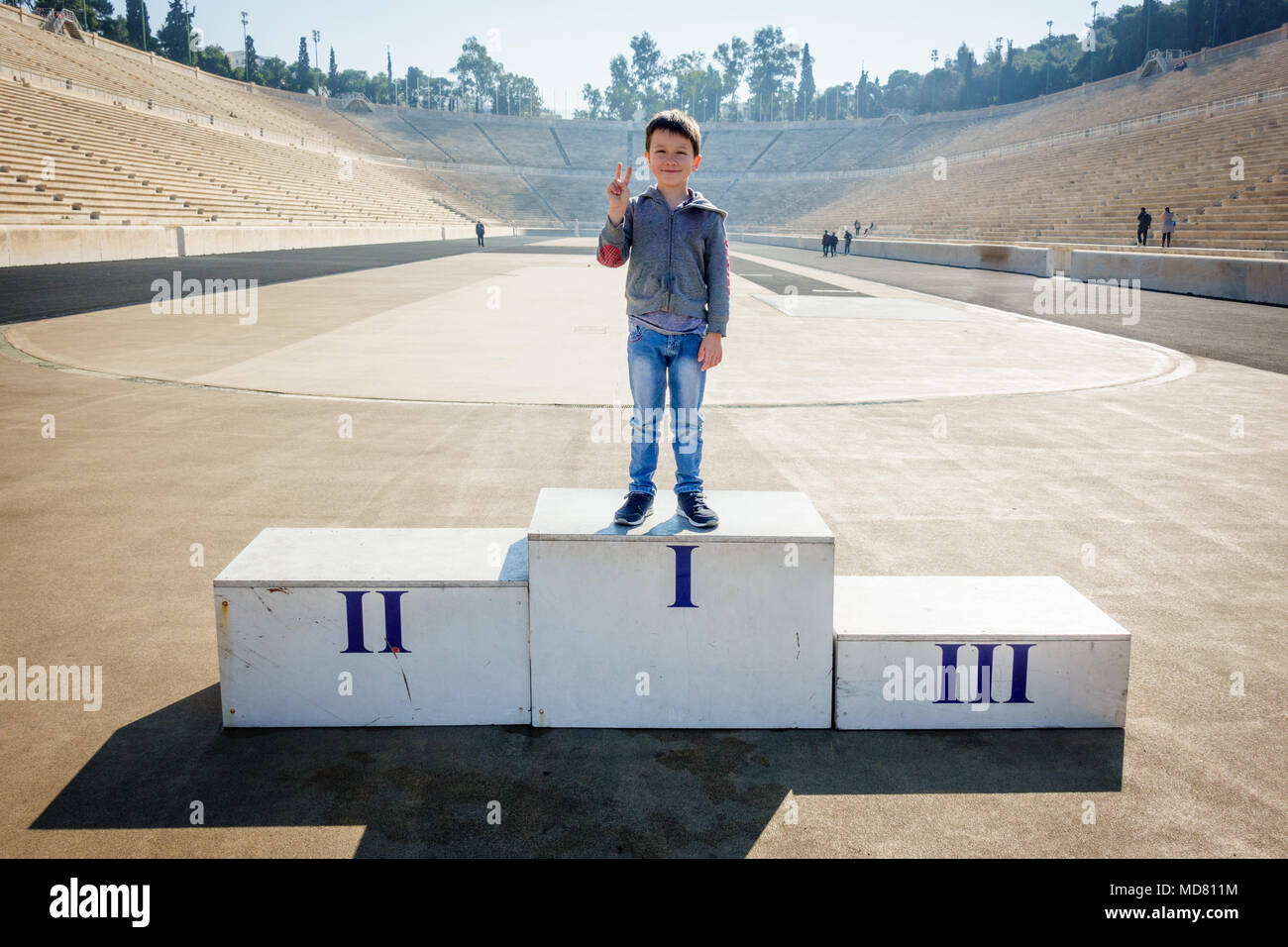 Boy posing on the winner's podium at Panathinaiko Stadium, Athens, Greece, Europe Stock Photo