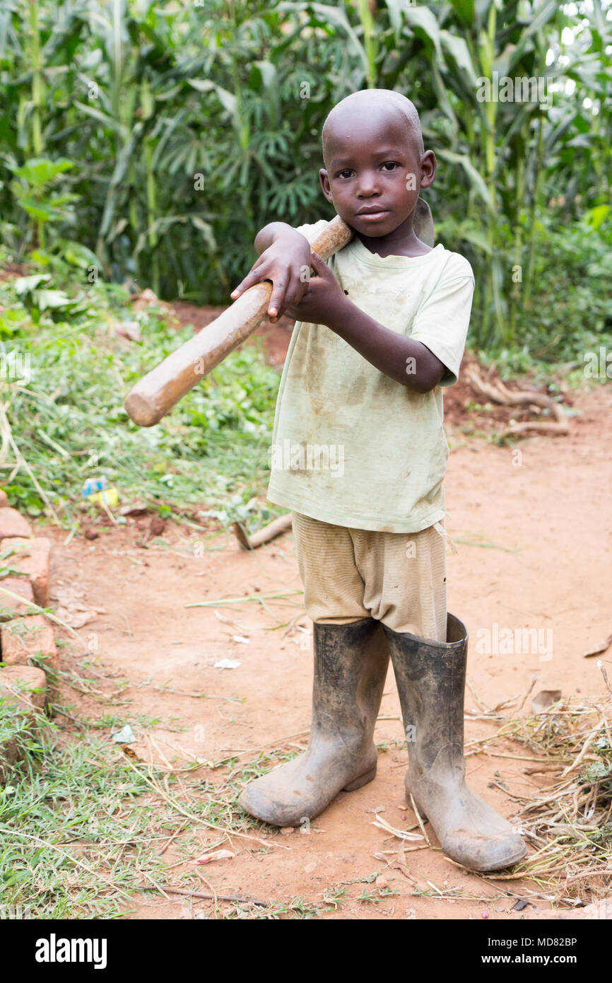 Uganda. 17 June 2017. A little Ugandan boy holding a hoe. Stock Photo