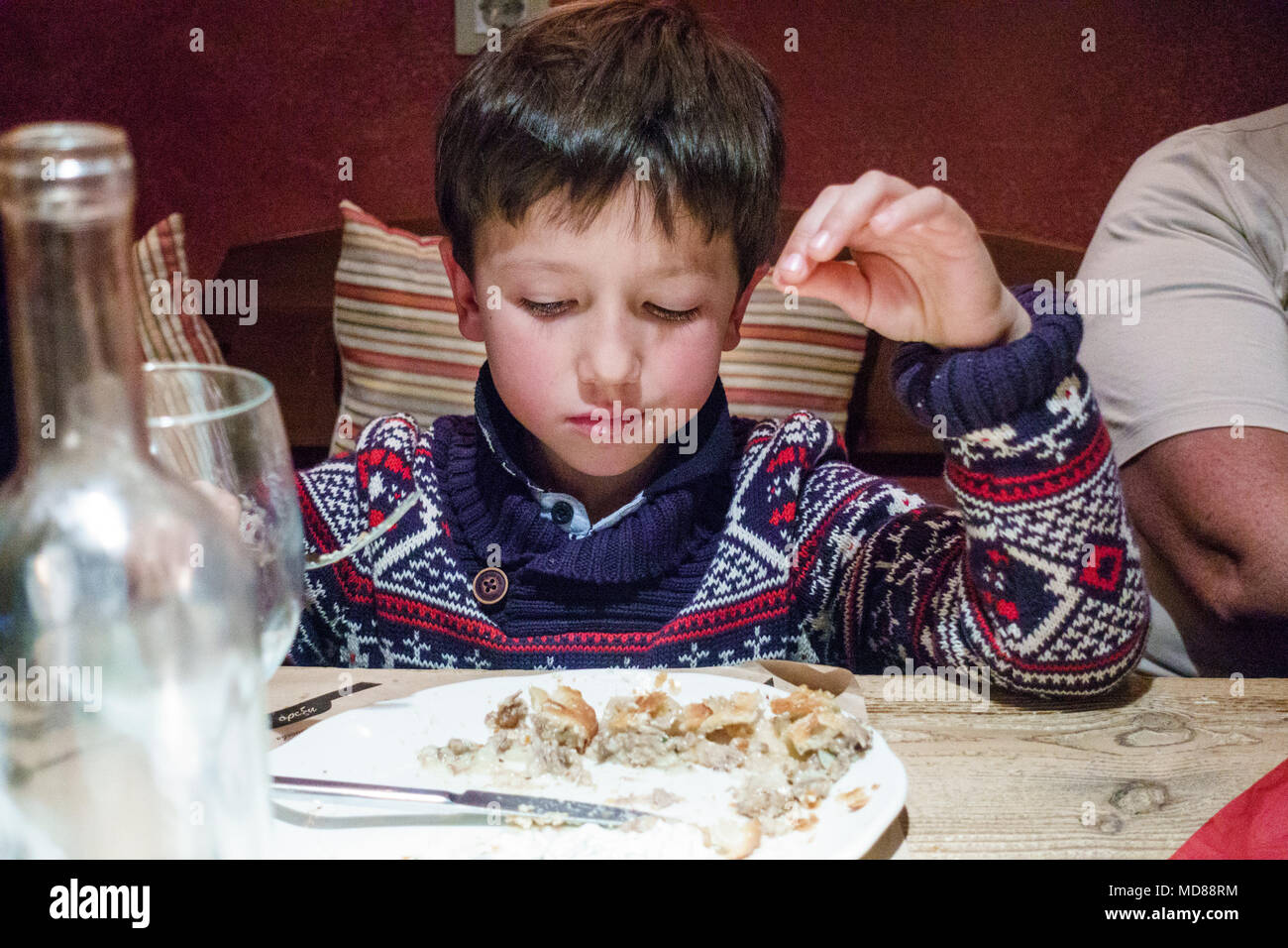 View of boy looking down at his meal, Greece Stock Photo