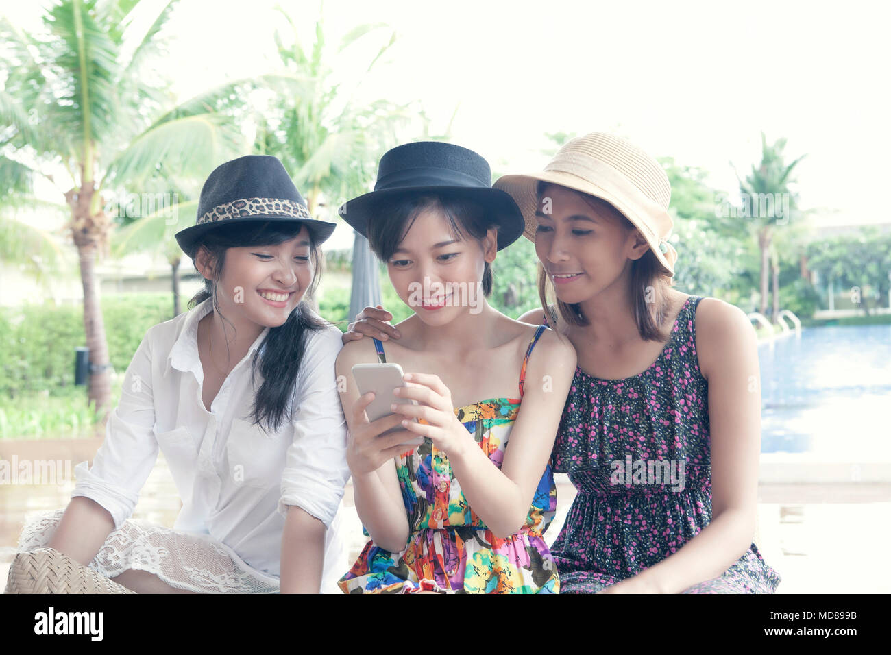 group of young asian woman friend watching on smart phone screen with toothy smiling face happiness emotion Stock Photo